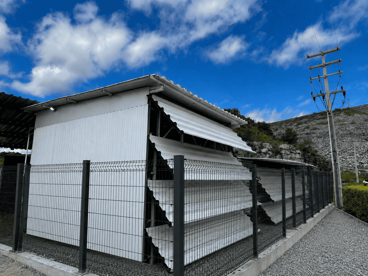 Original photograph of the exterior of a Hashlabs Bitcoin mining facility in Brazil, with fencing and utility infrastructure