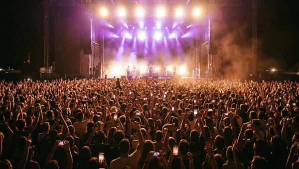 Crowded concert with artists playing on stage