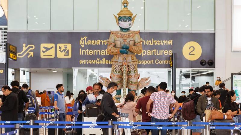 Travellers queuing at international departures and passport control in Bangkok's Suvarnabhumi airport
