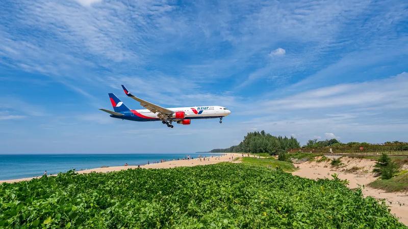 A wide-body jet on final approach over Mai Khao beach beside Phuket airport