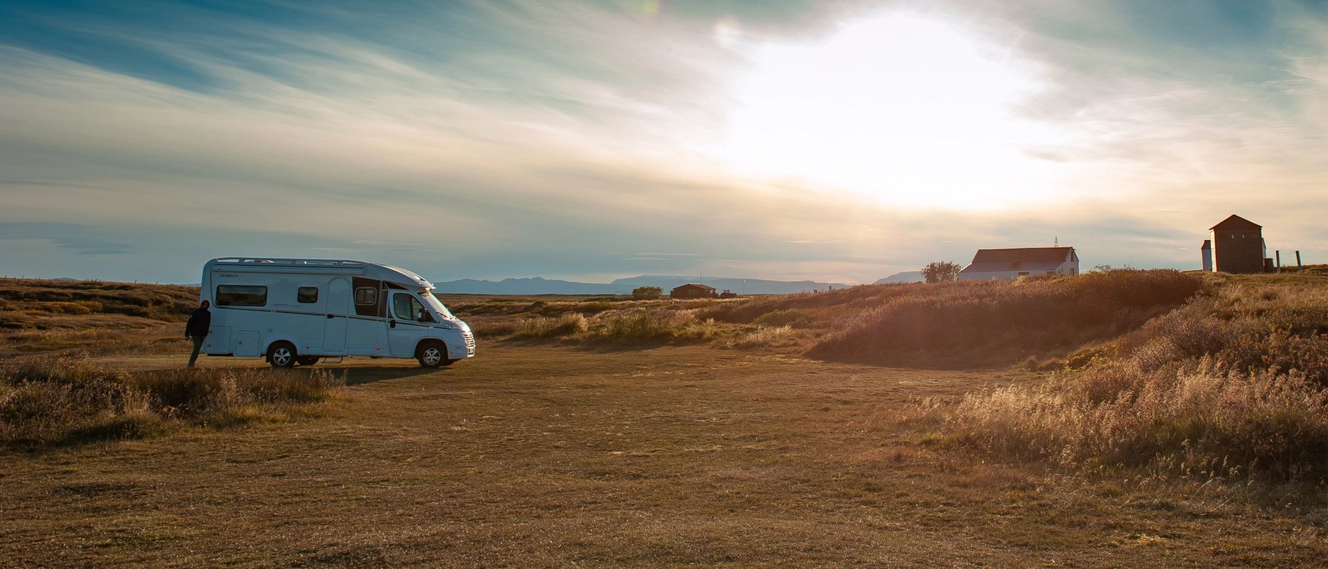 Campervan stands in the sunset.