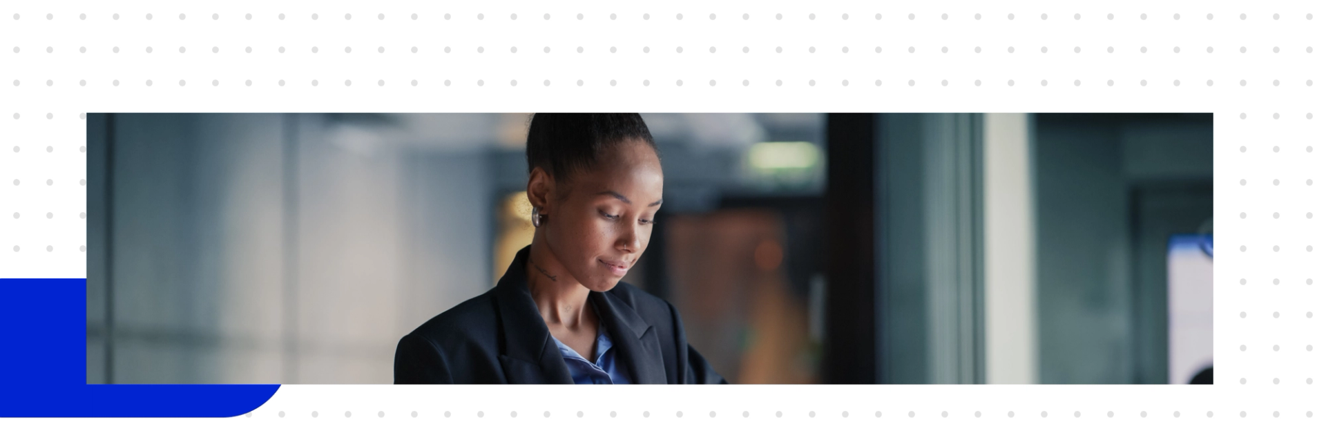 A woman in an office standing and looking at her tablet, studying B2B marketing automation