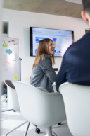 Salesfive Kollegin sitzt mit Kollegen im Meeting.