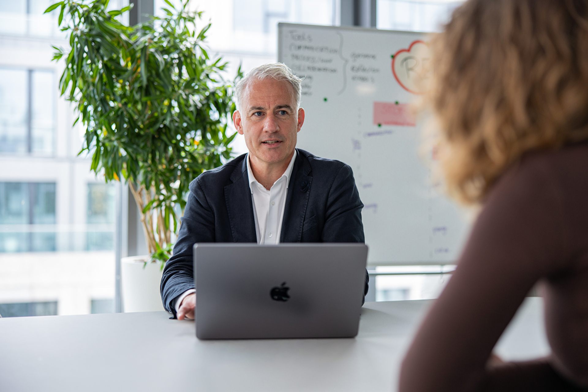 Zwei Salesfive Kolleg:innen sitzen sich im Meeting gegenüber. 