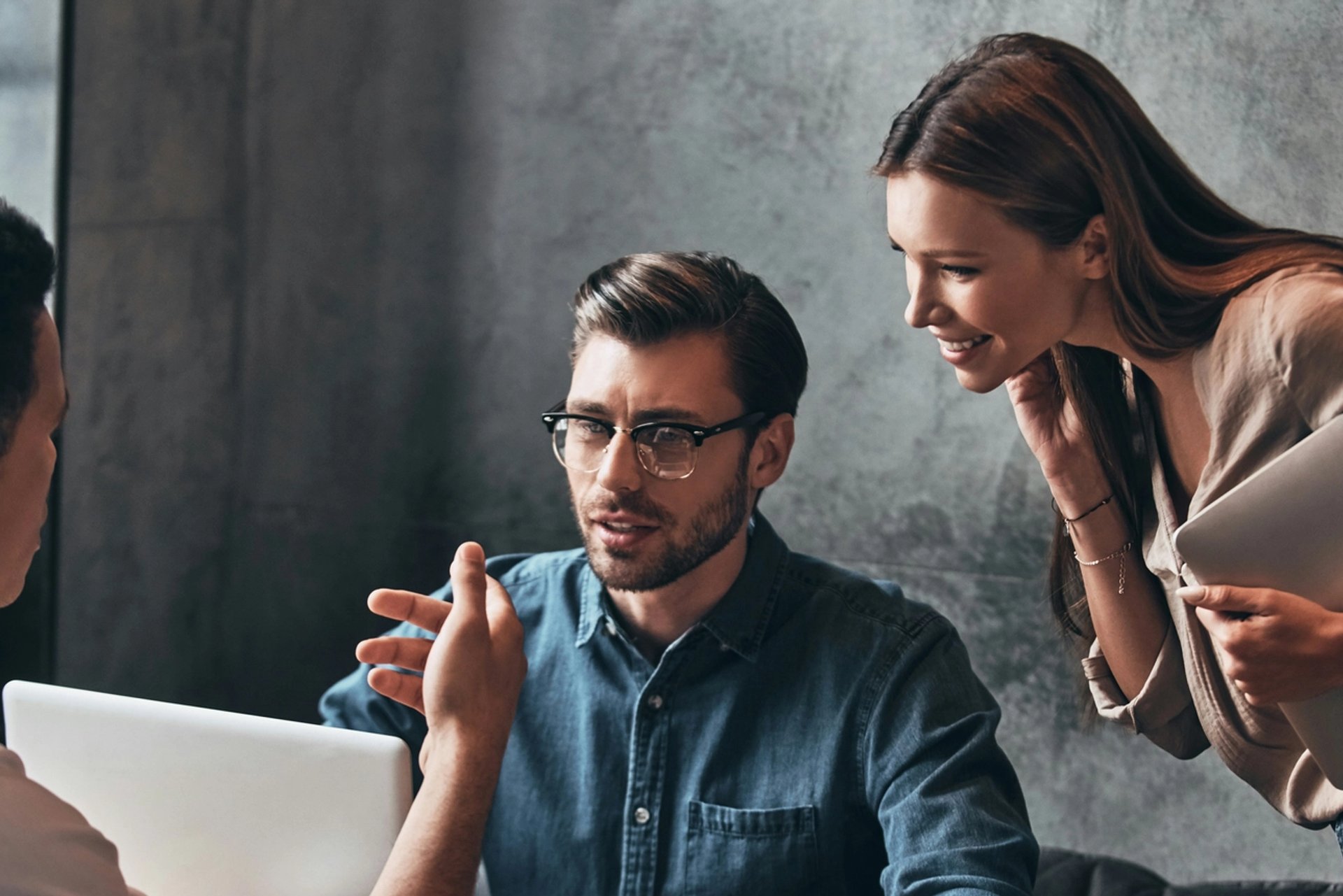 Group of people discussing at laptop