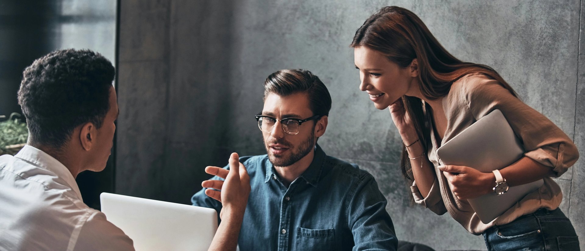 Group of people discussing at laptop