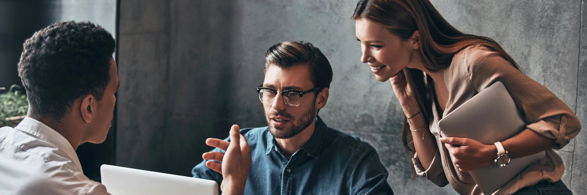 Group of people discussing at laptop