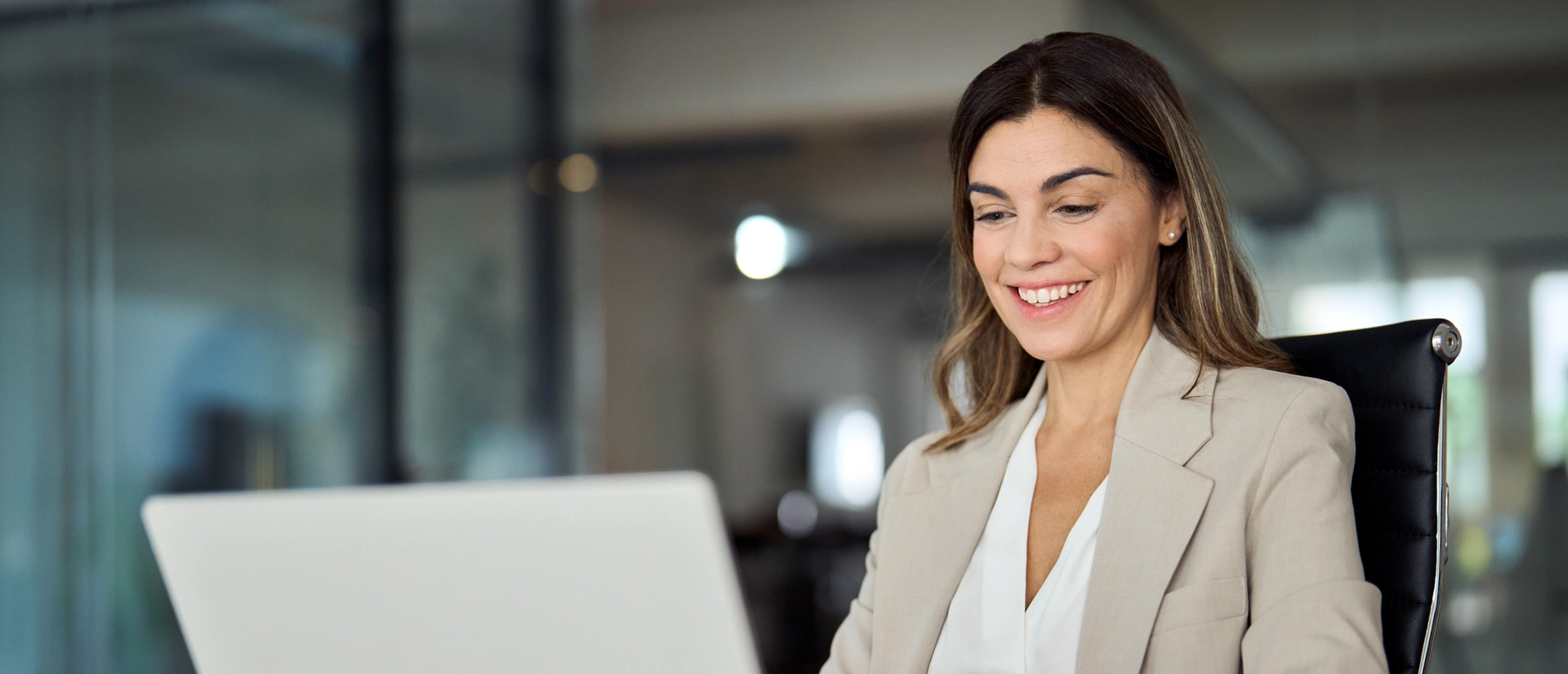 Frau am Laptop, die mit Salesforce Marketing Cloud Account Engagement arbeitet