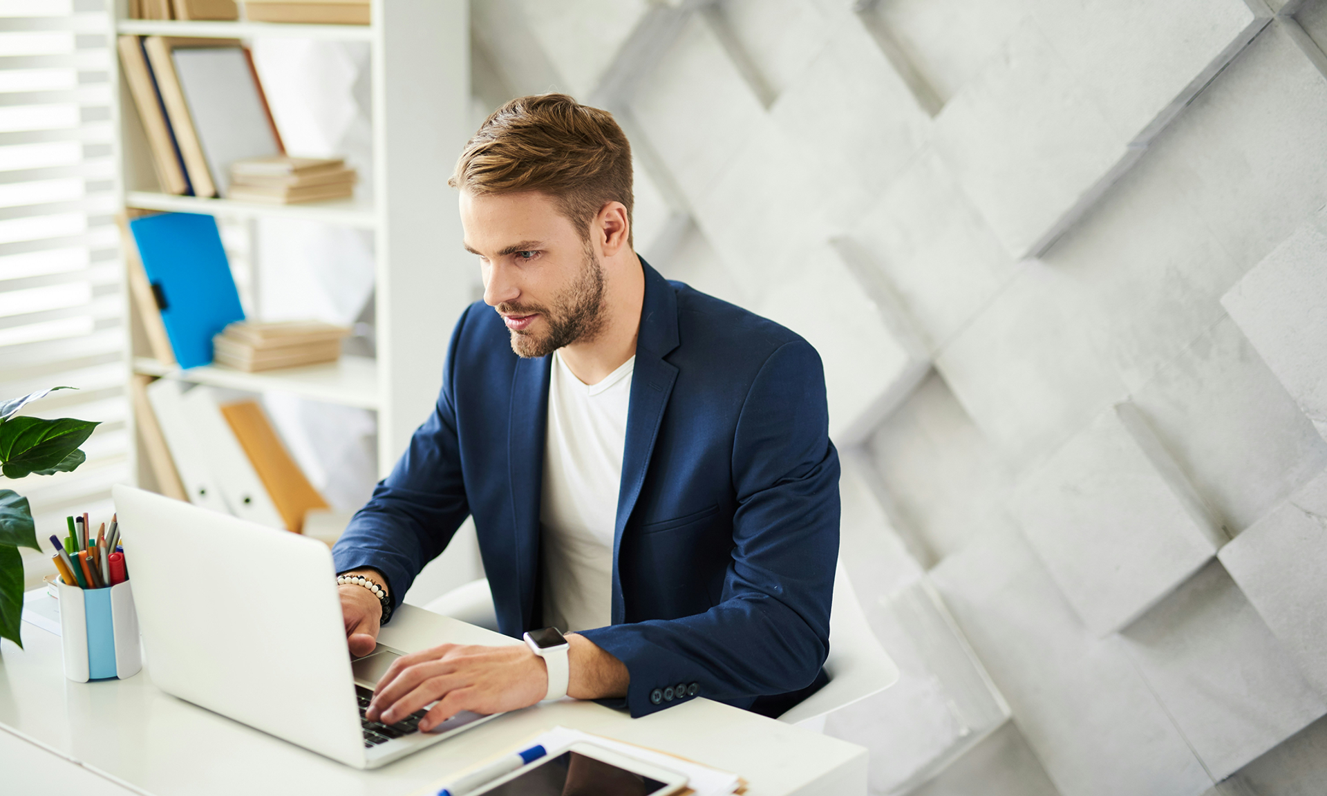 Man in blue suit at laptop