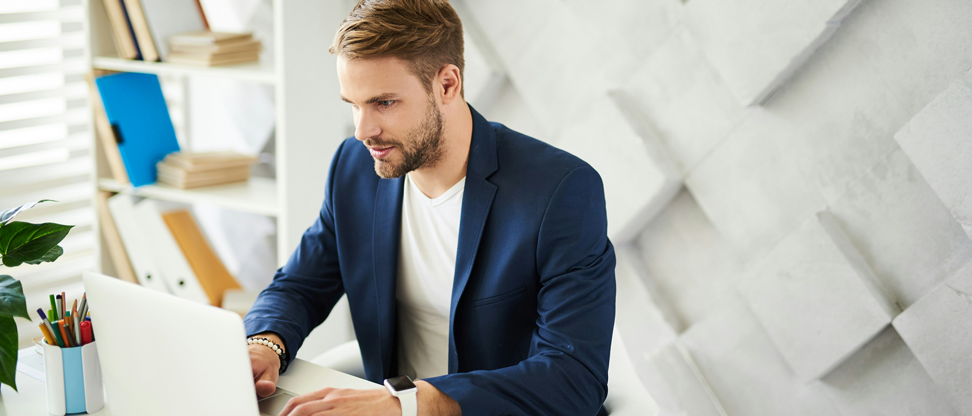 Mann in blauem Anzug am Laptop