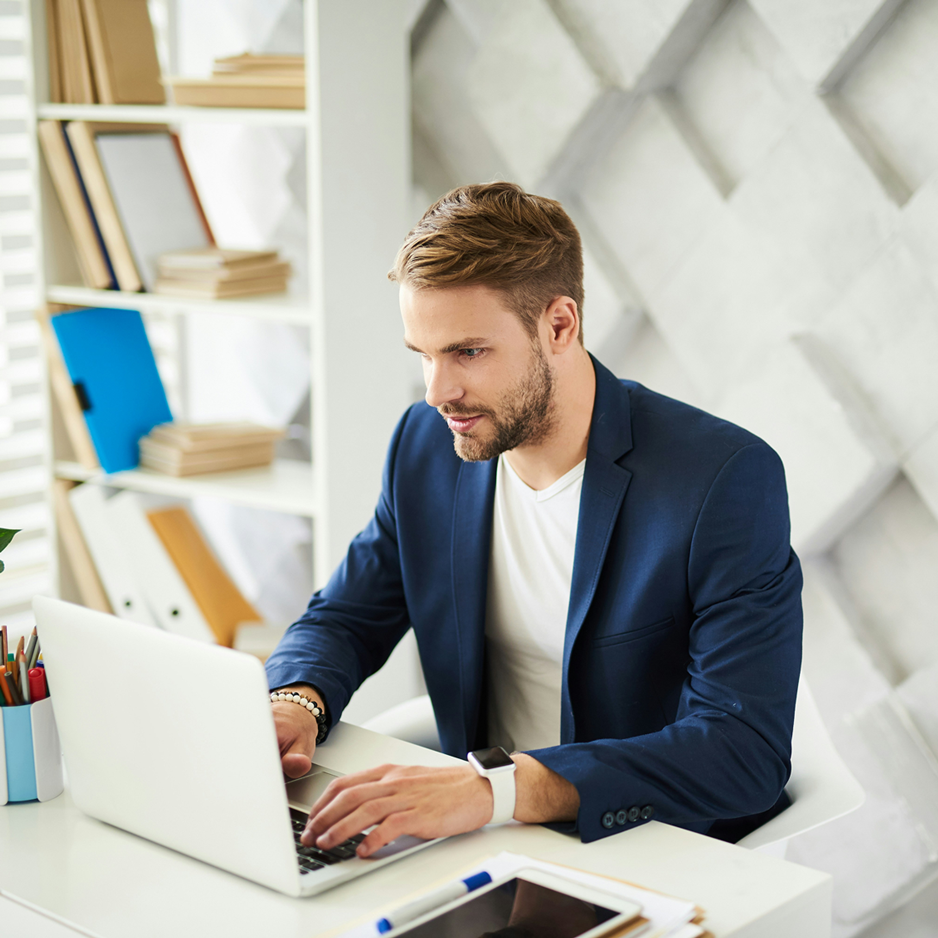 Mann in blauem Anzug am Laptop
