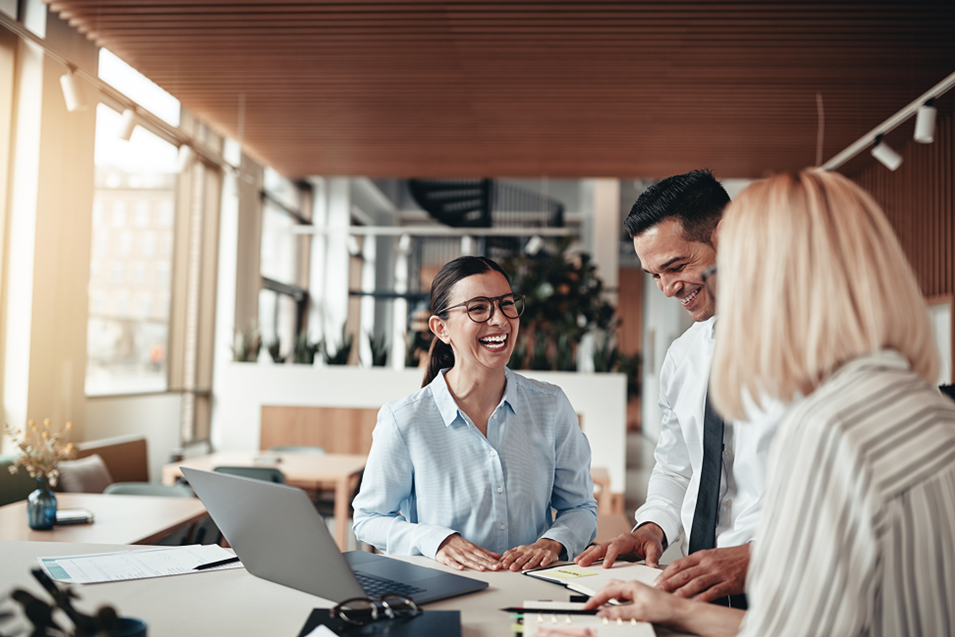 Two women and one man are conversing in a business context, and one man is conversing in a business context.