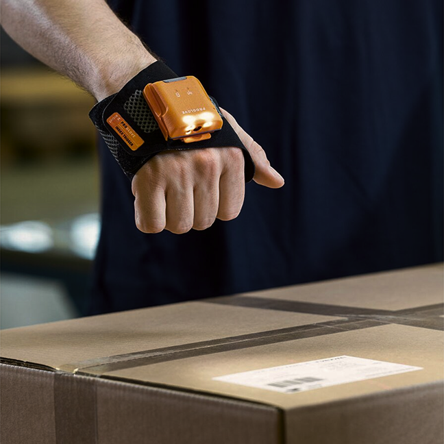 Orangener Scanner ist auf Handrücken angebracht und scannt Strichcode auf Paket.