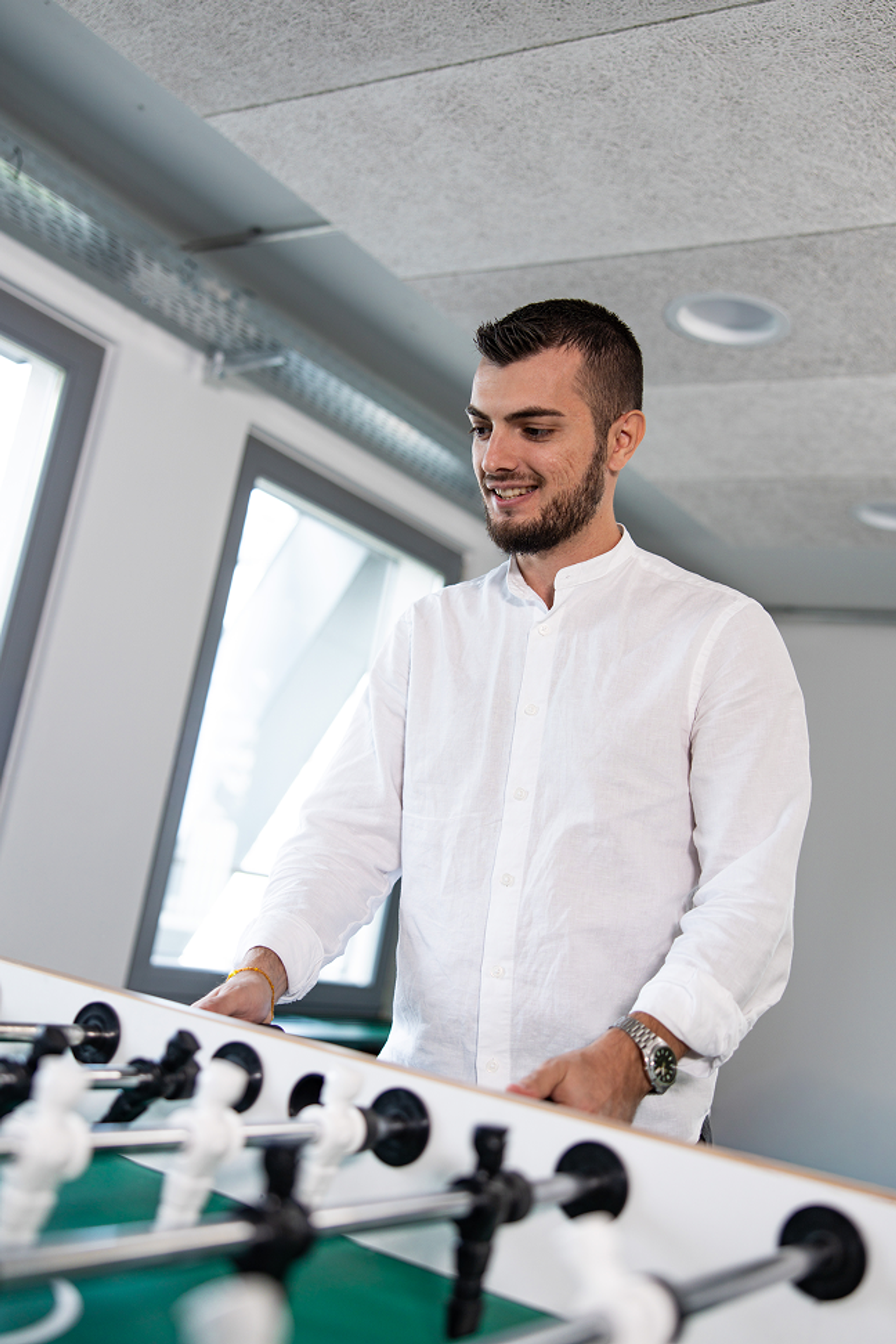 Salesfive Kollege spielt Tischkicker.