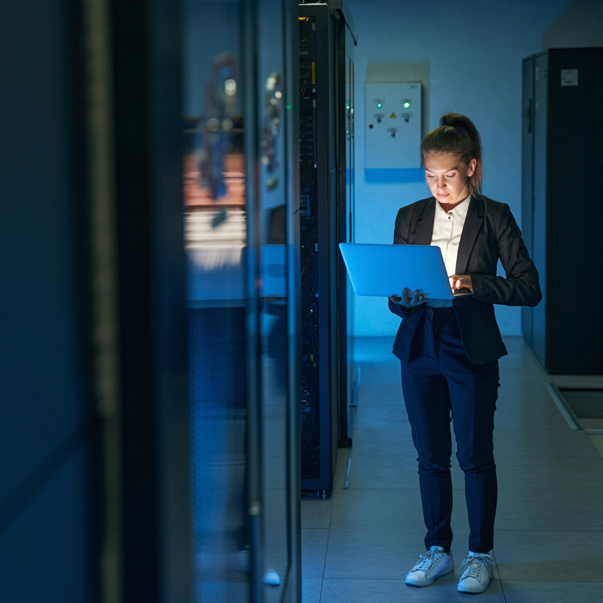Frau mit Laptop in einem Rechenzentrum