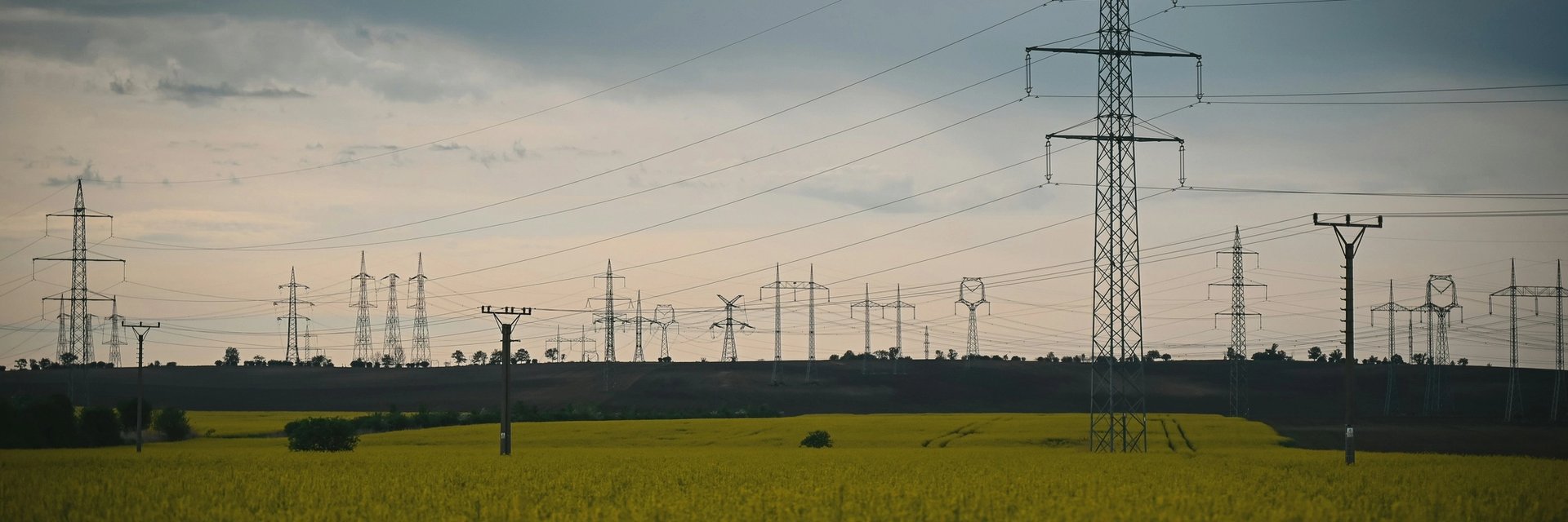 Arbeiter steht zwischen Windrädern und Solaranlage.