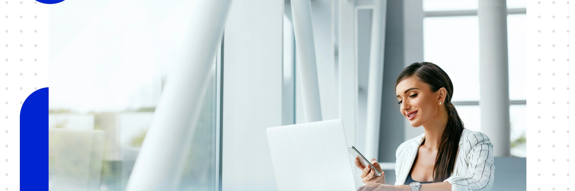 Woman on a laptop in front of a large floor-to-ceiling window front