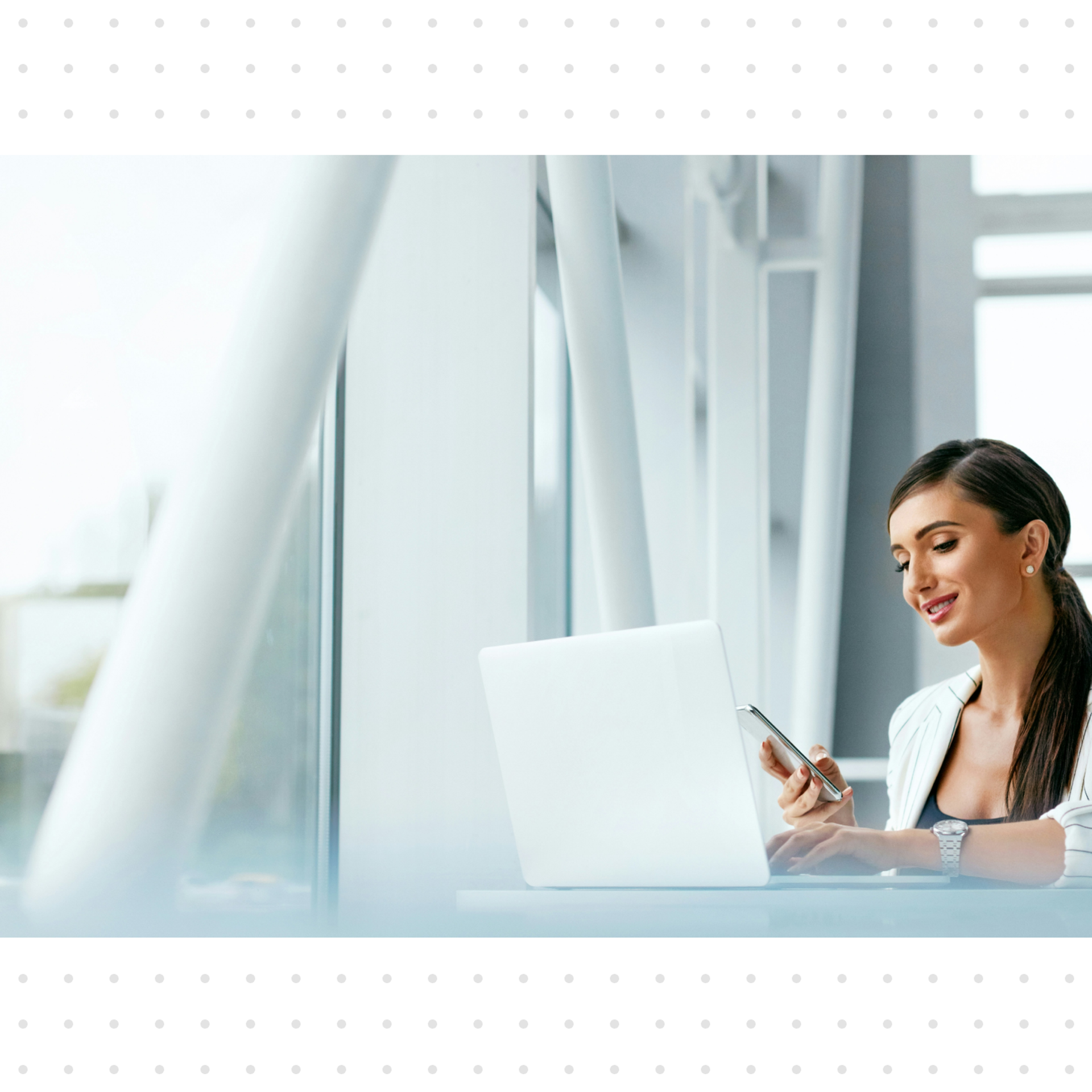 Woman on a laptop in front of a large floor-to-ceiling window front
