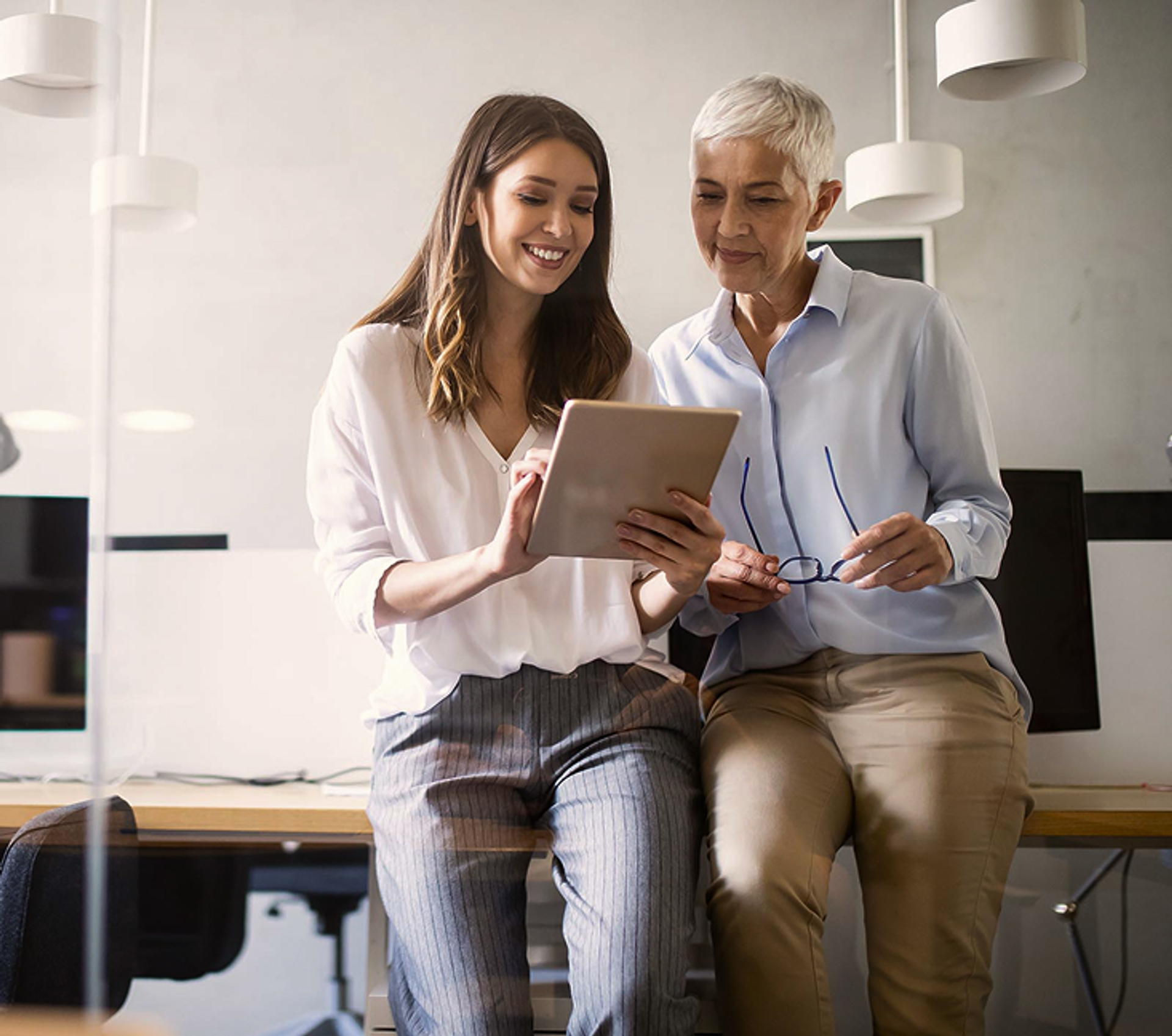 Zwei Frauen schauen auf ein Tablet.