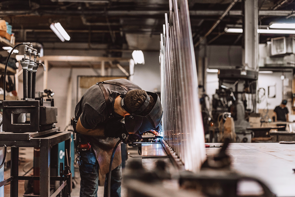 Ein Mann schweißt in einer Werkstatt.