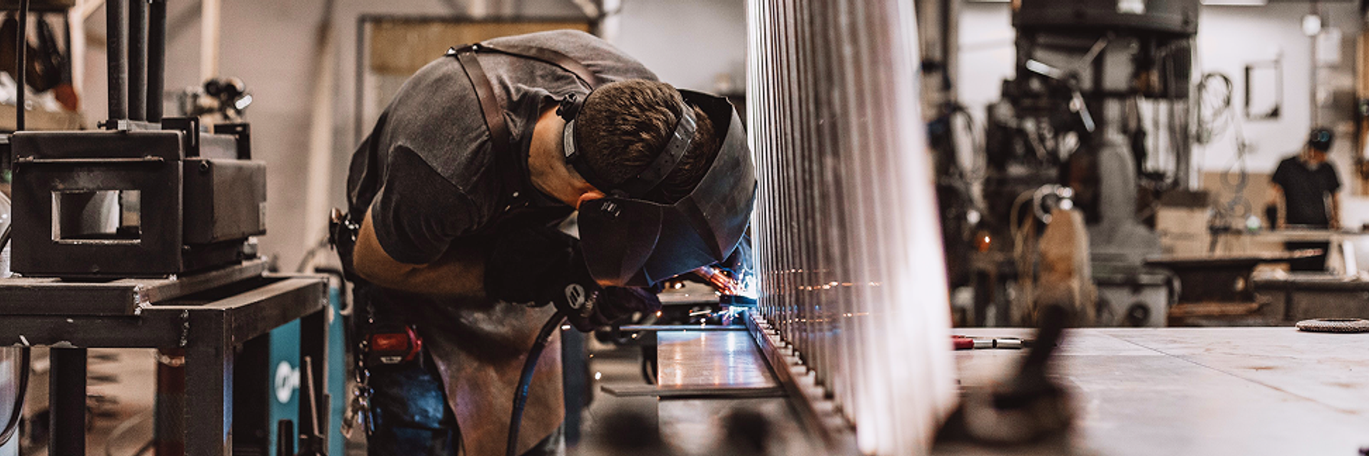 Ein Mann schweißt in einer Werkstatt.