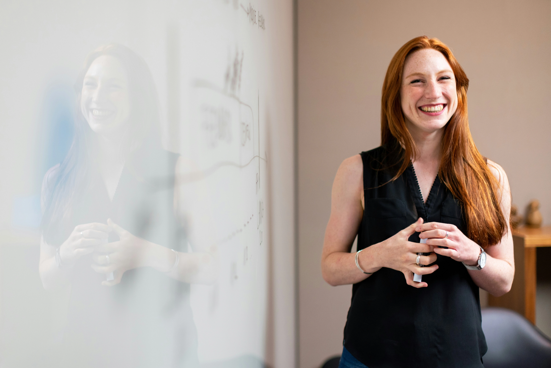Frau steht an Whiteboard und beschäftigt sich mit Change-Management.