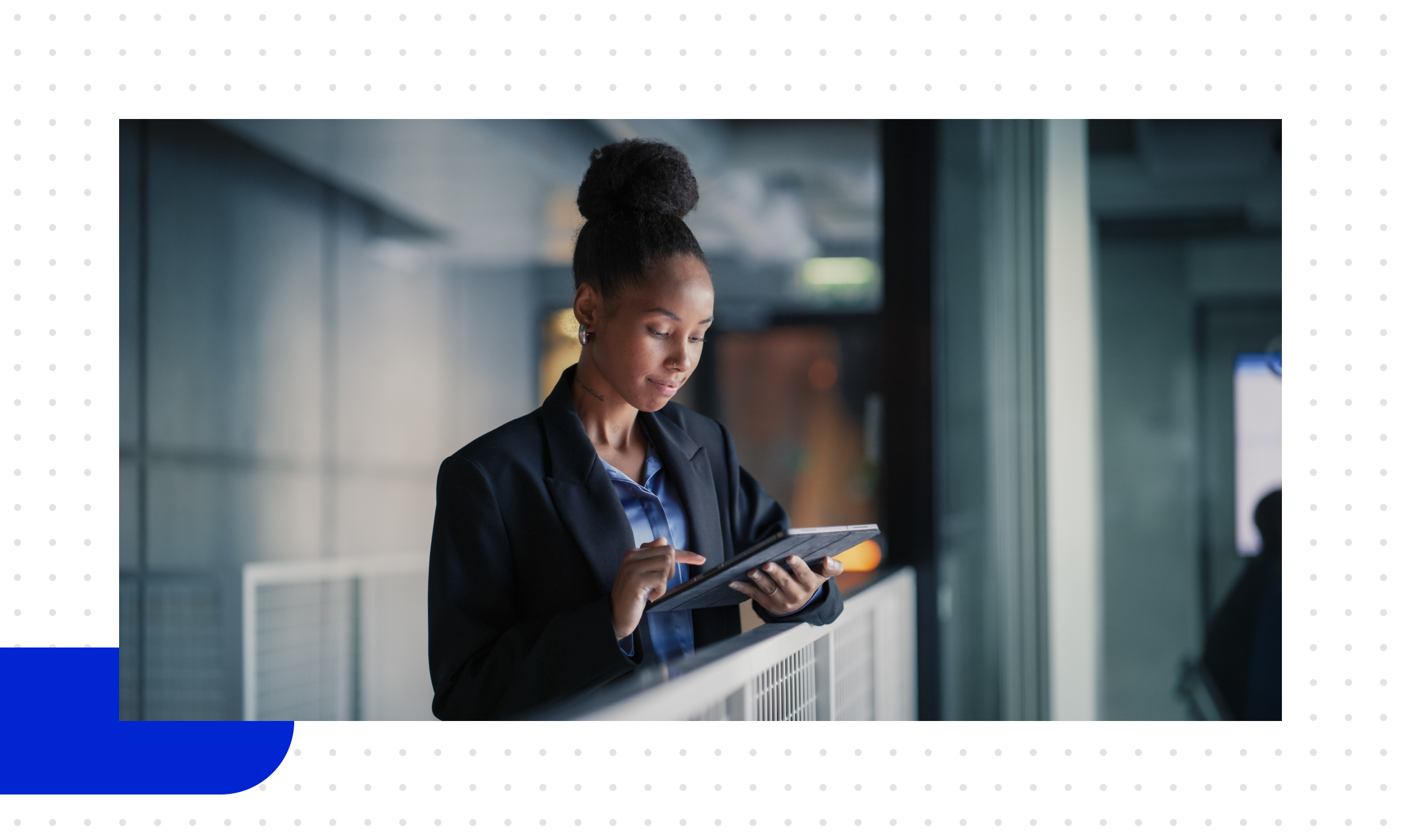 Eine Frau im Büro steht und schaut auf ihr Tablet, sie beschäftigt sich mit B2B-Marketingautomatisierung