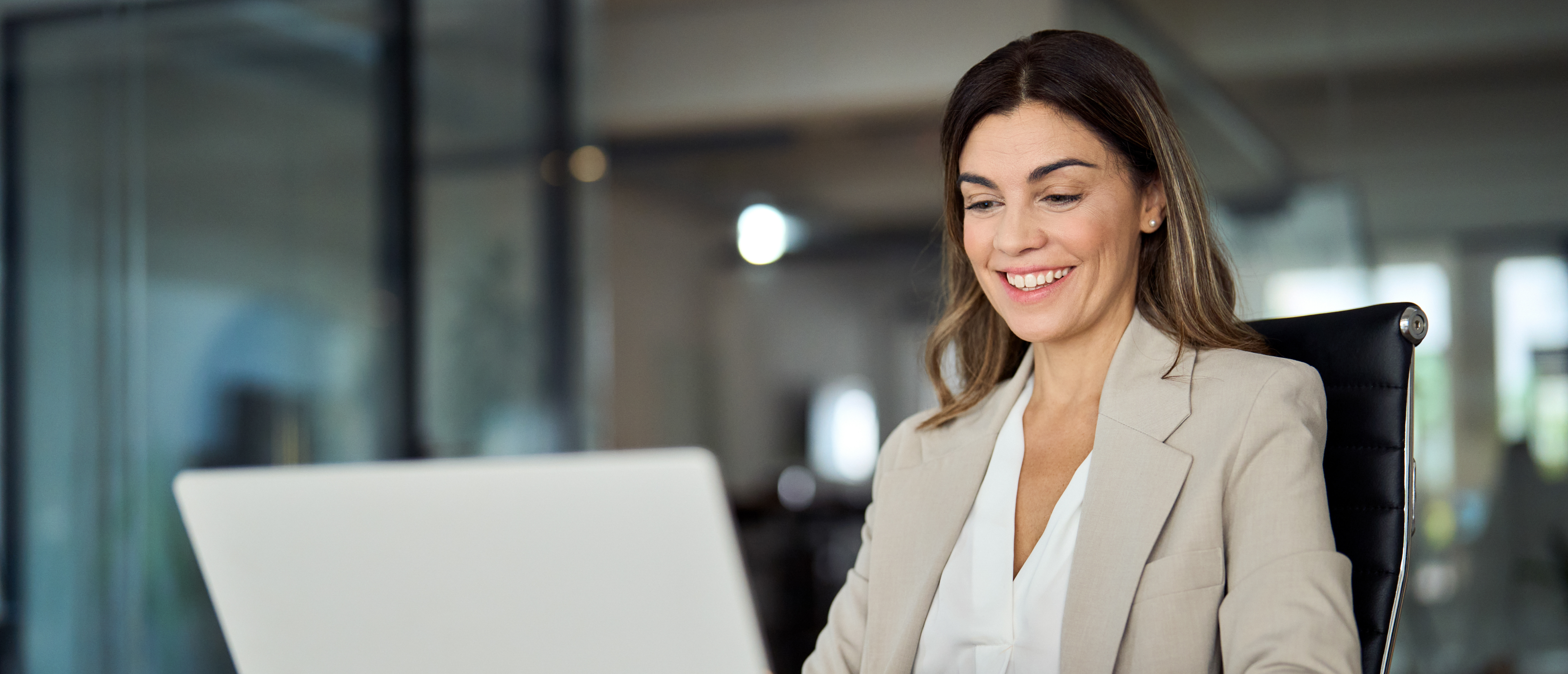 Frau am Laptop, die mit Salesforce Marketing Cloud Account Engagement arbeitet