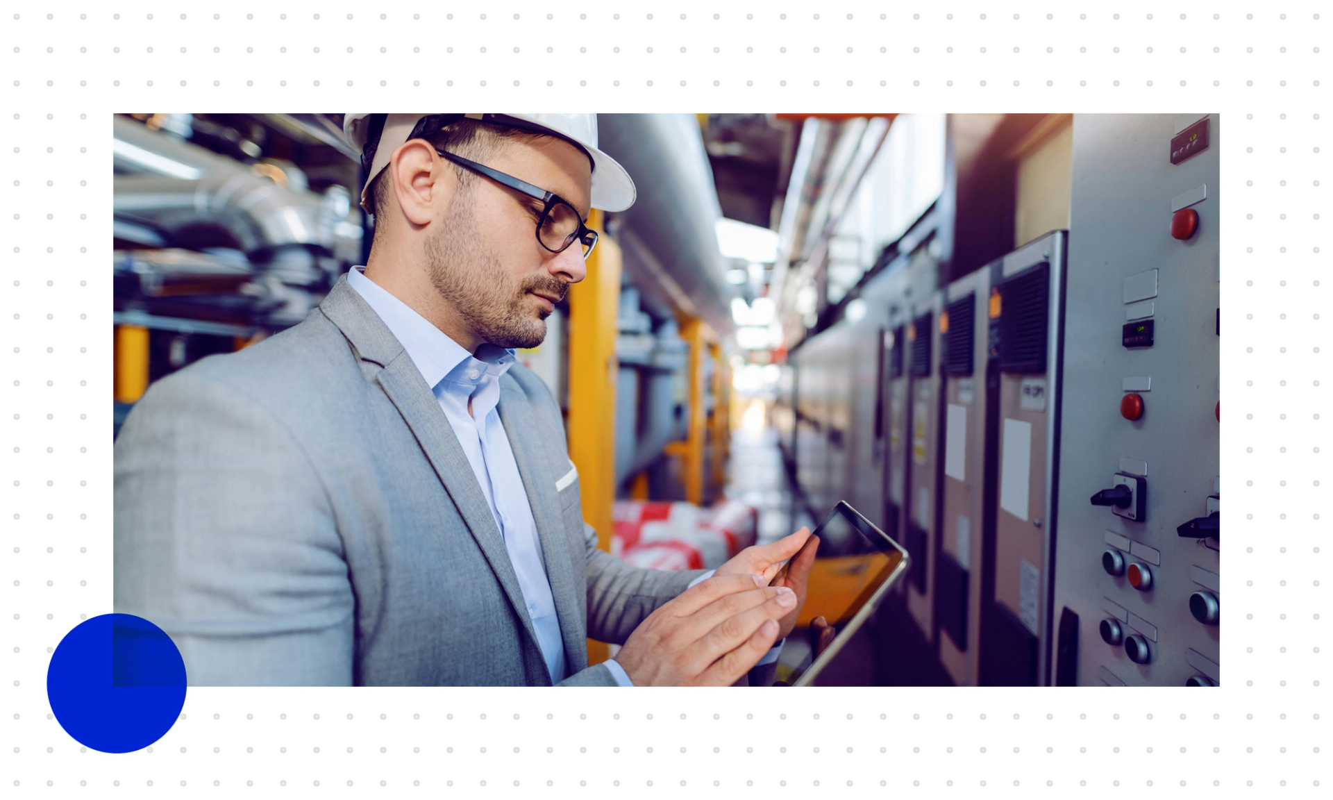 Ein Mann mit Helm und Anzug prüft im Produktionsumfeld sein Tablet, um zu sehen, wie KI den Service unterstützt