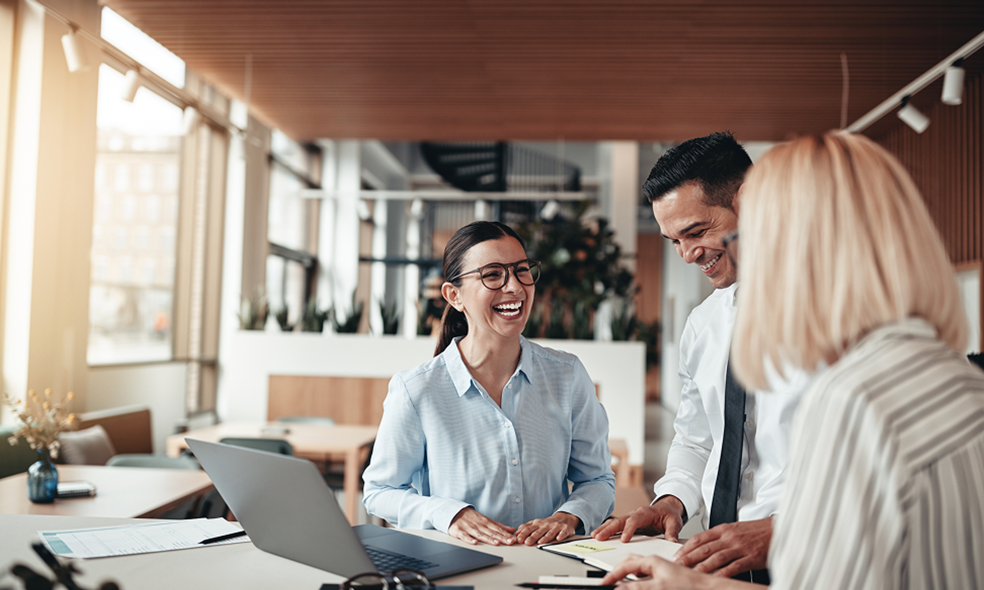Zwei Frauen und ein Mann sprechen im Business-Kontesuen und ein Mann unterhalten sich im Buiness-Kontext.xt.