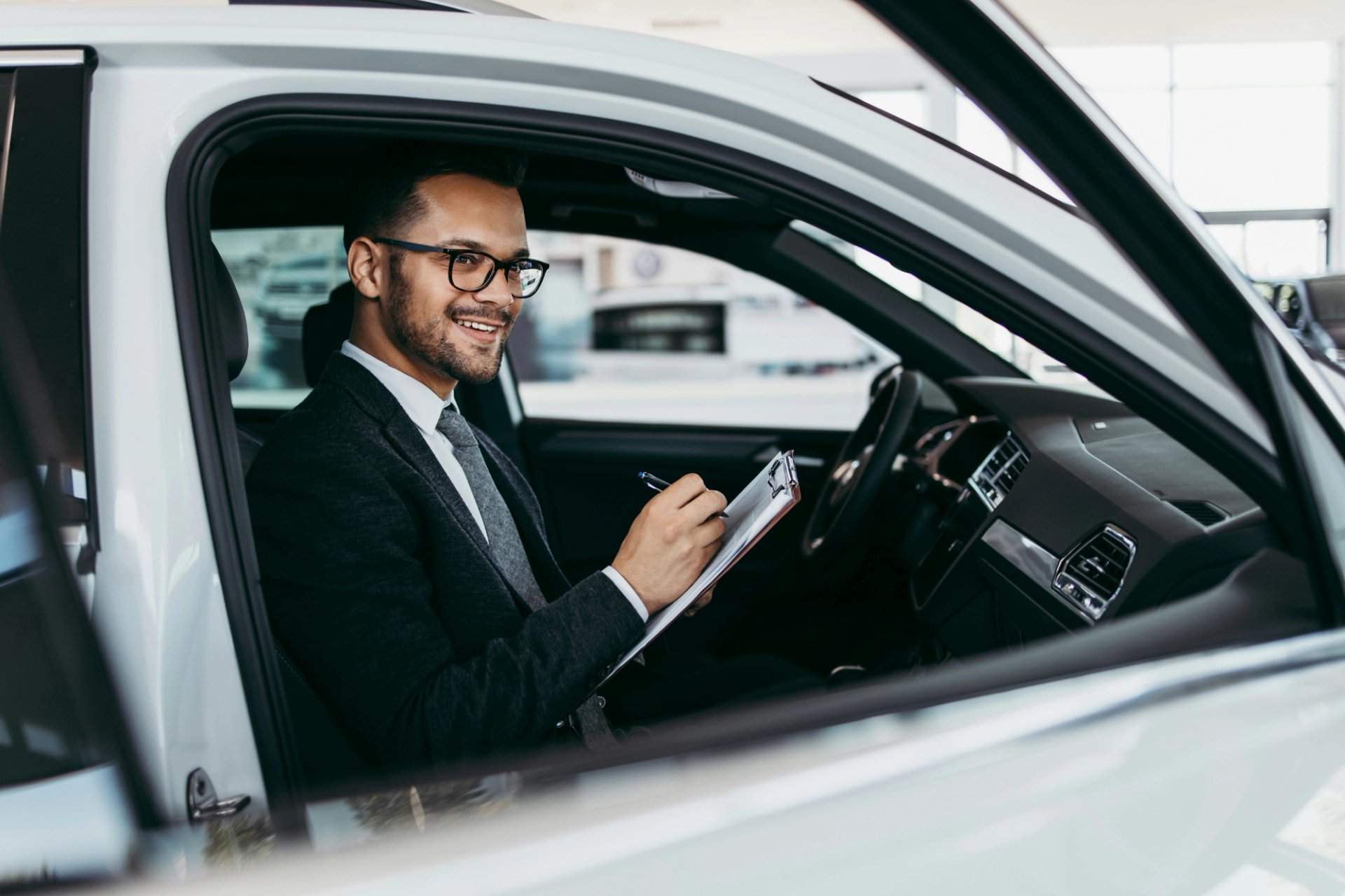 Verkäufer sitzt in Auto und bewertet es. 