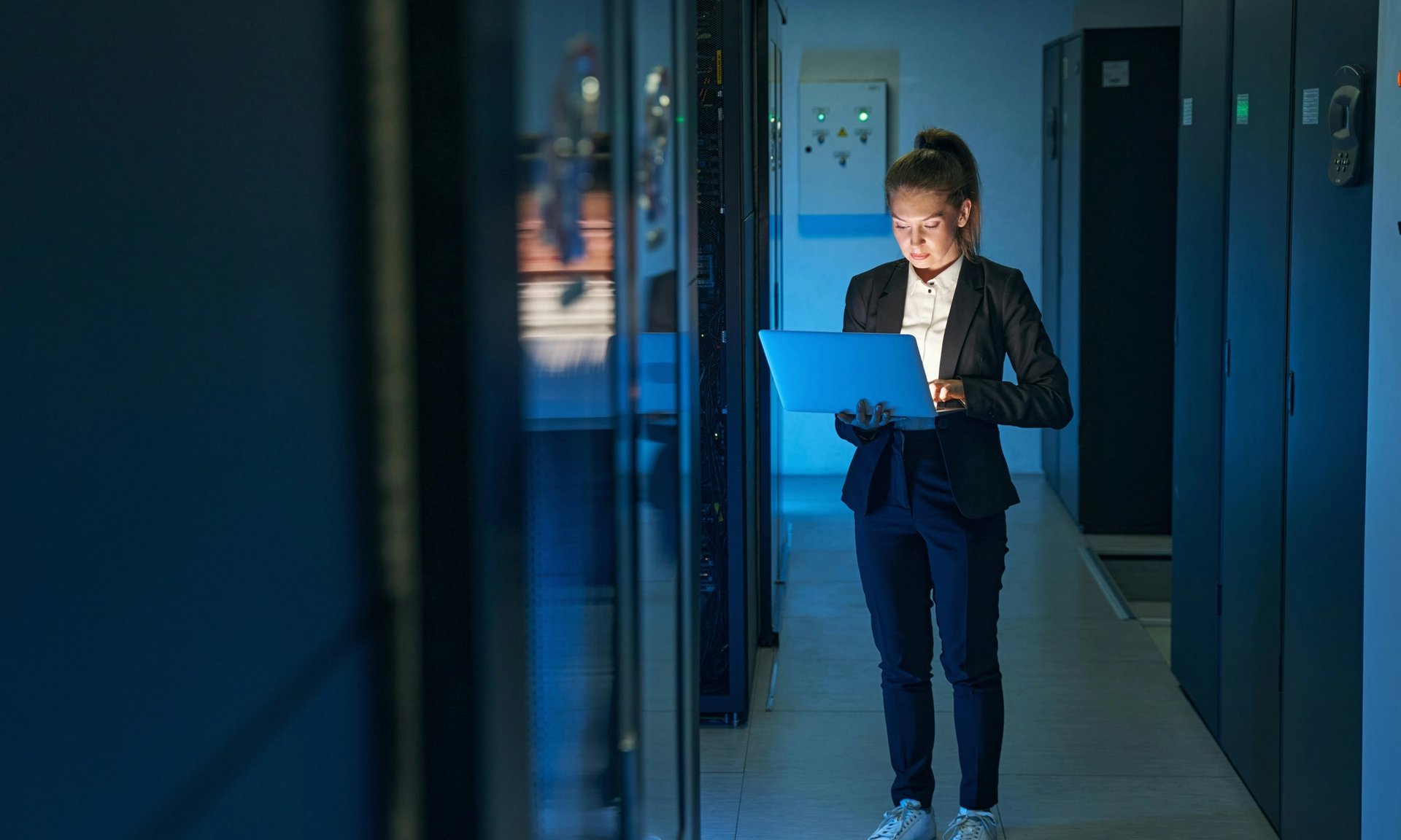 Frau mit Laptop in einem Rechenzentrum