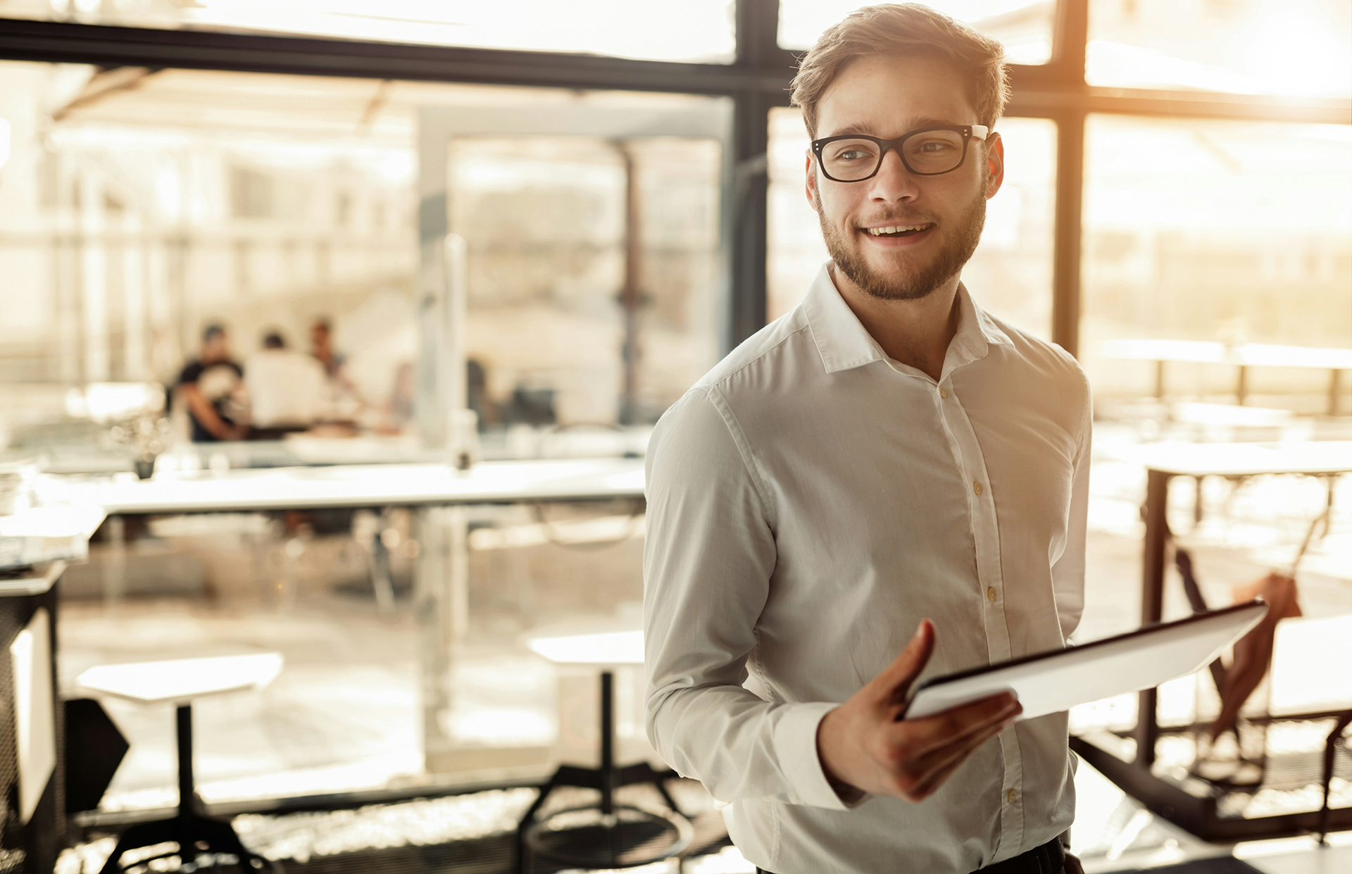 Junger Mann mit weißem Hemd und Tablet mit Salesforce Commerce Cloud in der Hand.