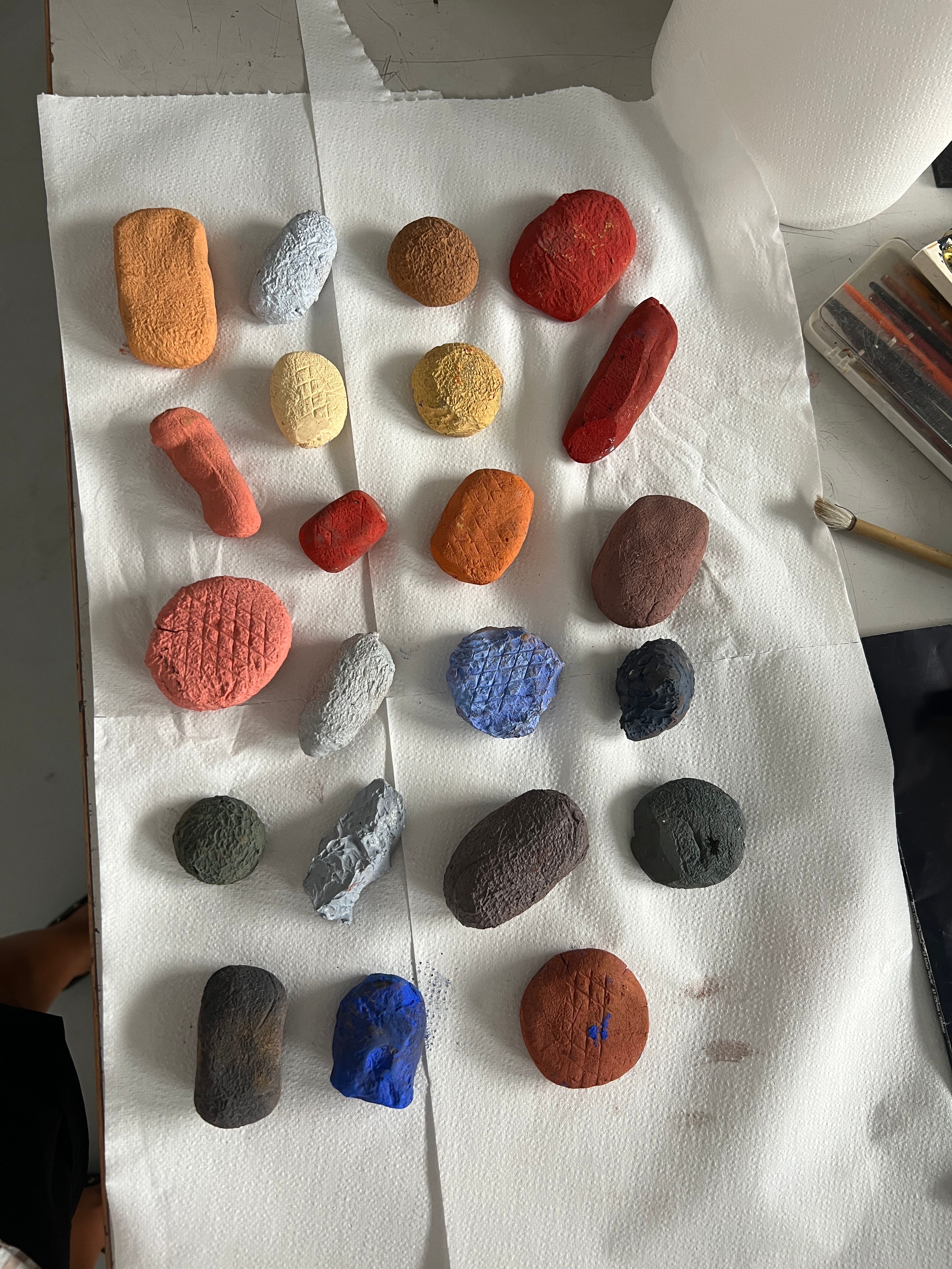 Small, colorful, textured, irregularly shaped objects are laid out on white paper towels.