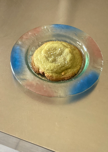 A salt-sprinkled light green cookie on a colorful glass plate.