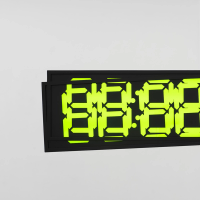 A digital clock showing "88:88" in bright green on a black screen, mounted on a white wall.