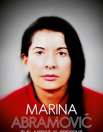A woman with dark hair and a serious expression, wearing a red top, looks directly forward. Text below reads "MARINA ABRAMOVIĆ THE ARTIST IS PRESENT."