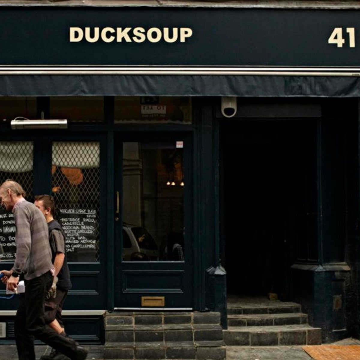 Exterior view of "DUCKSOUP" restaurant at number 41, with two people walking past.