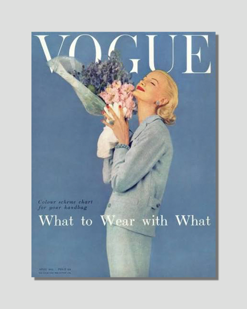 A vintage image of a blonde woman in a blue suit smelling a bouquet of pink and purple flowers, with "VOGUE" at the top and "What to Wear with What" below.