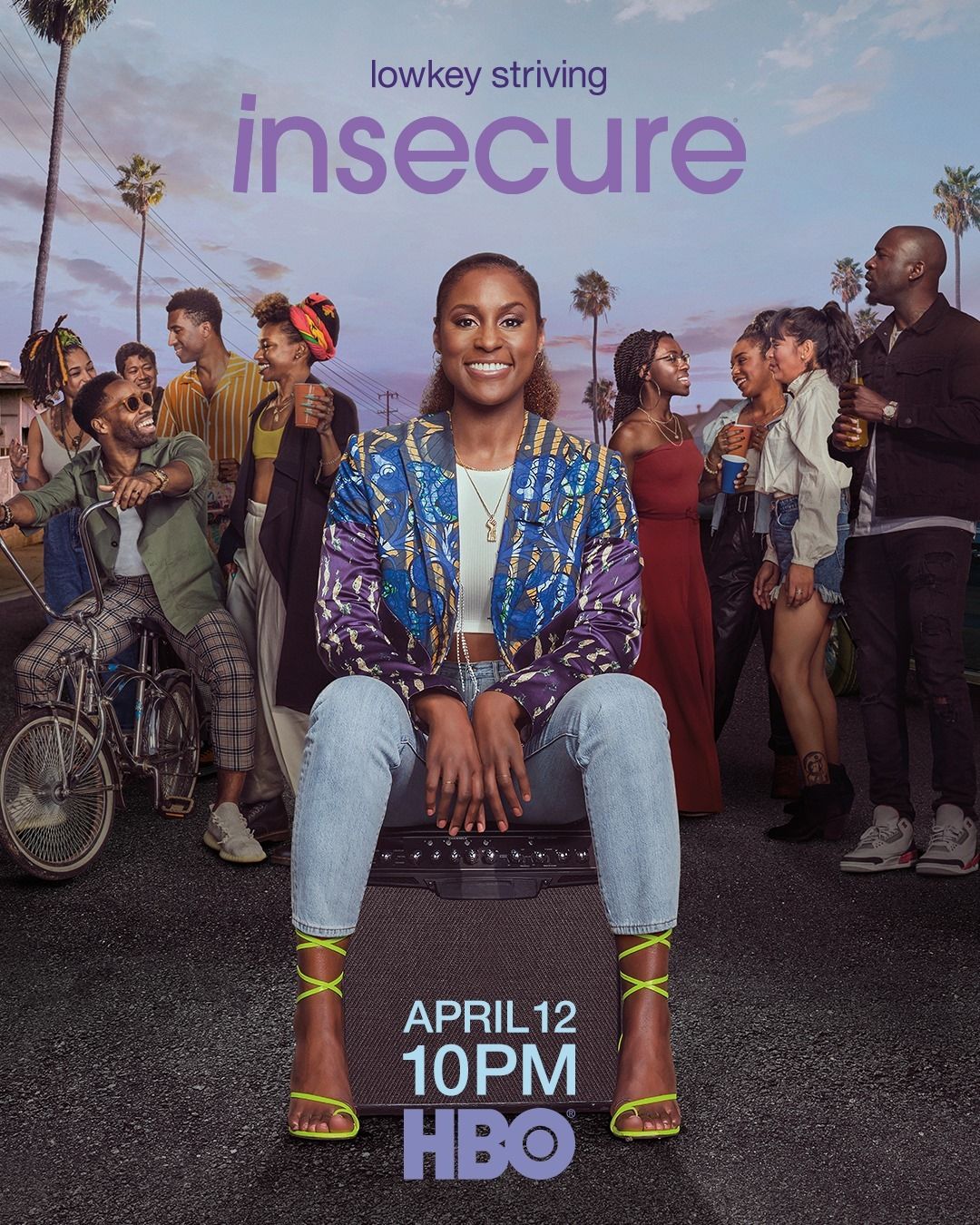 Issa Rae smiles, seated on an amplifier in a colorful blazer, surrounded by diverse friends outdoors, with the text "lowkey striving insecure" and "APRIL 12 10PM HBO."
