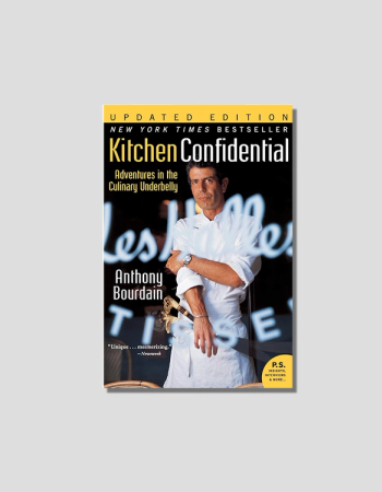 Book cover for Anthony Bourdain's "Kitchen Confidential," featuring the author in a chef's coat holding a large knife.
