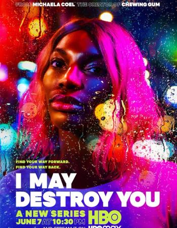 An 'I May Destroy You' poster showing Michaela Coel with pink hair, illuminated by vibrant neon lights, seen through a rain-splattered window.