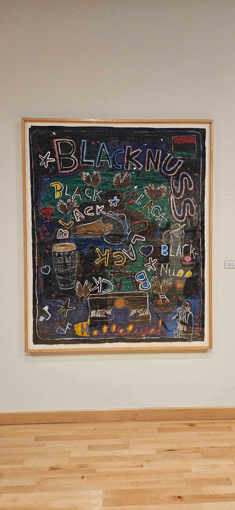 A framed, vibrant mixed-media artwork with the word "BLACKNUSS" repeated, depicting musicians, musical instruments, and cultural symbols on a dark, textured background.