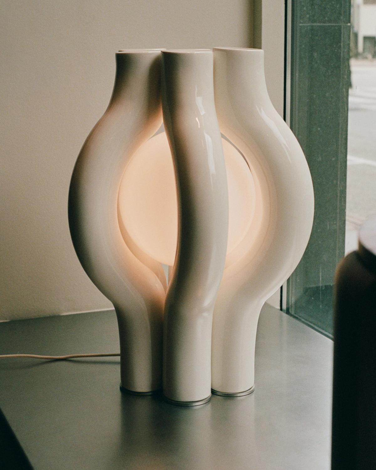 White sculptural lamp with a glowing circular center.