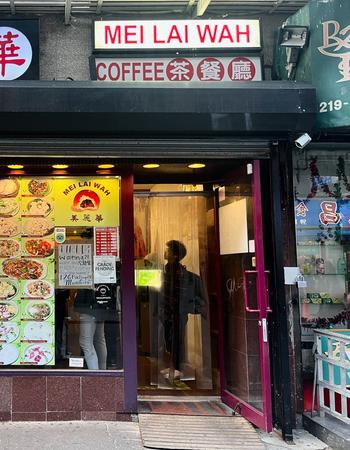 Storefront of Mei Lai Wah Chinese restaurant, with food photos displayed in the windows and an open door.