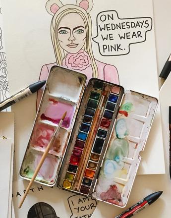 A watercolor palette, markers, and pencils are surrounded by hand-drawn sketches, including one of a woman with bunny ears and the quote "On Wednesdays we wear pink."
