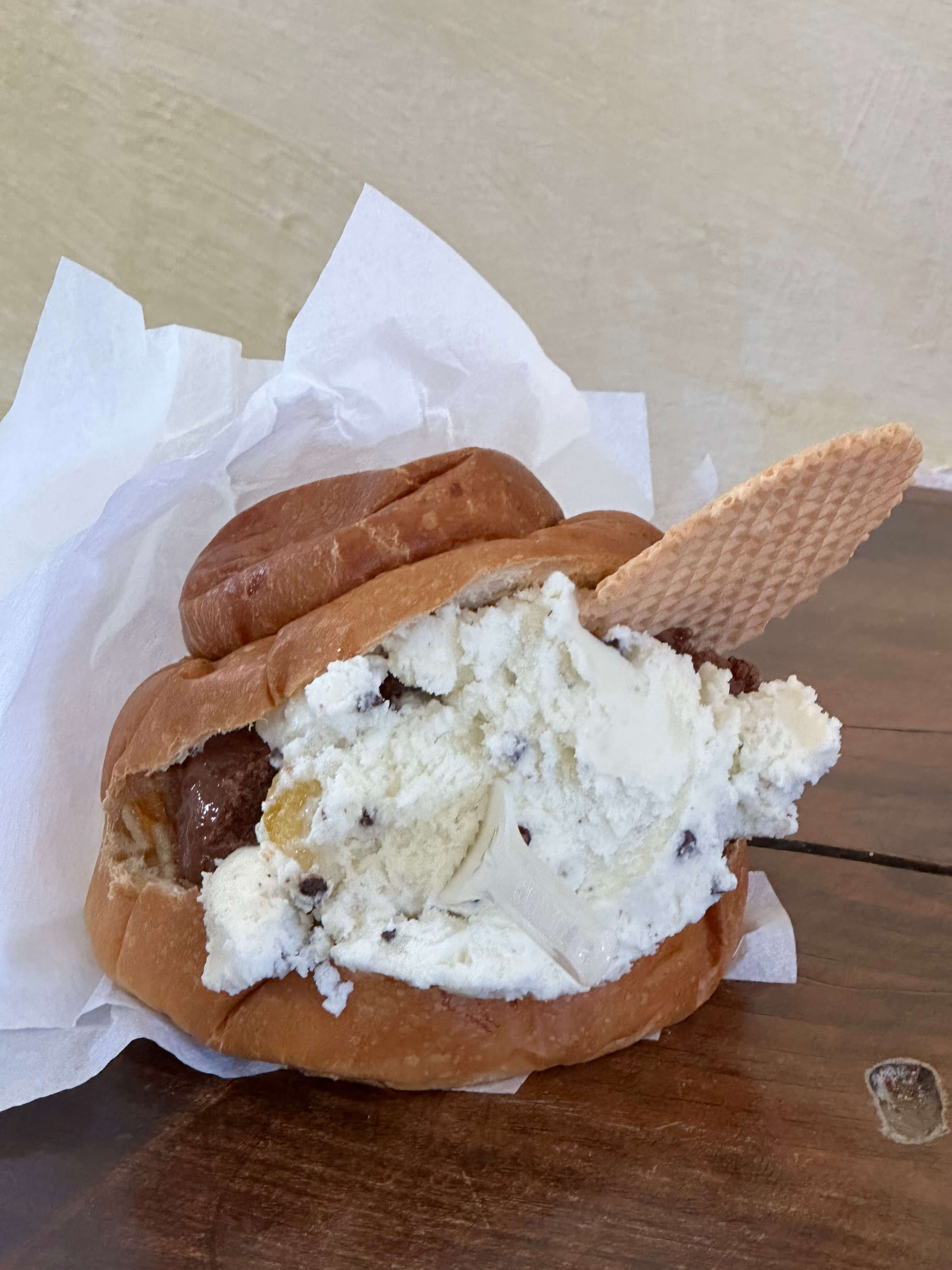 Brioche bun filled with stracciatella and chocolate gelato, with a wafer cookie.