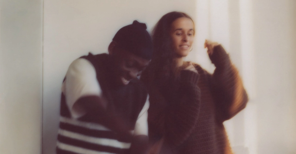 A blurry, warm-toned photo of a joyful man and woman dancing.