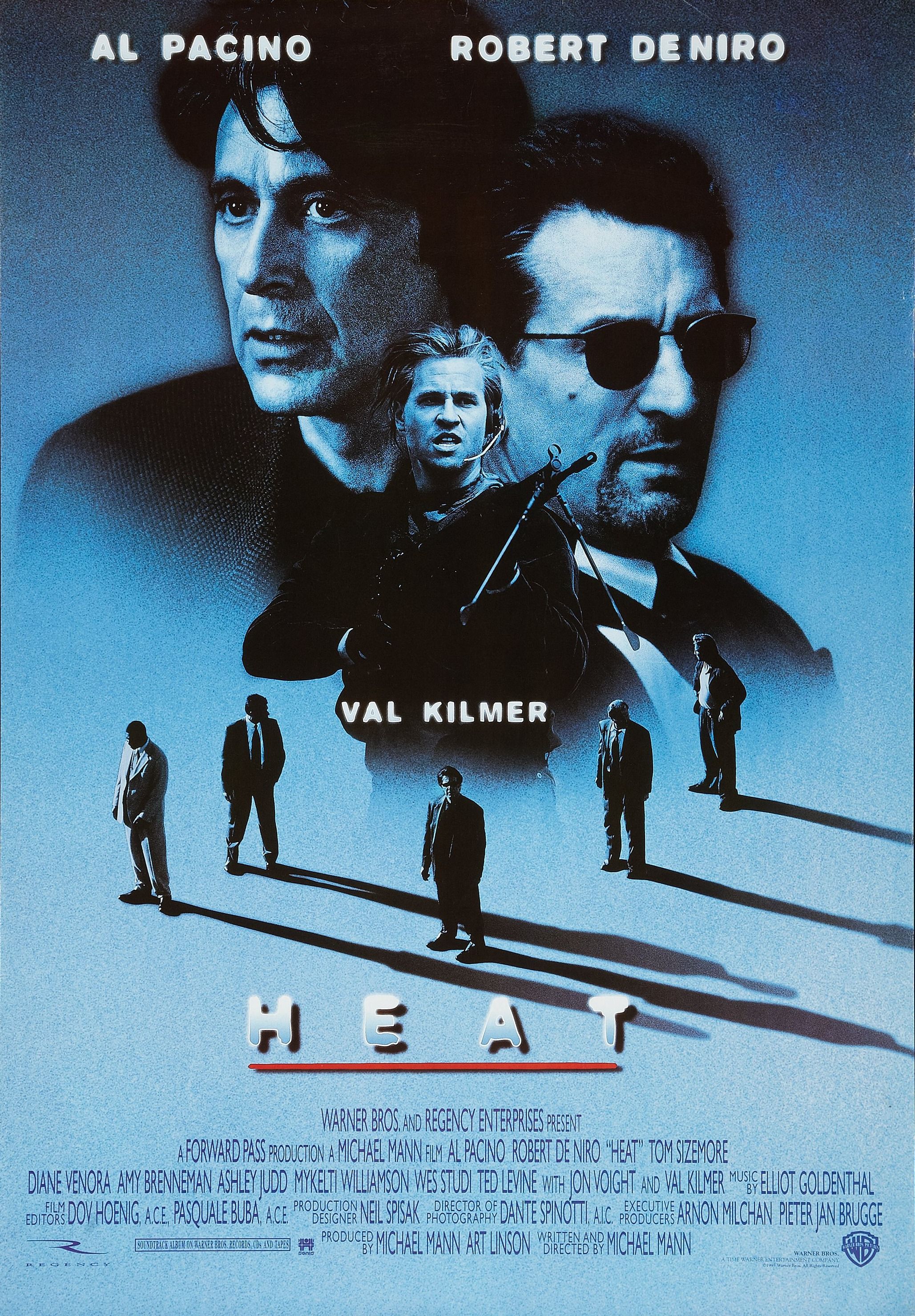 A blue-tinted movie poster for "Heat" featuring large images of Al Pacino and Robert De Niro, with a smaller image of Val Kilmer holding a gun, and five silhouetted men in suits walking below the title.