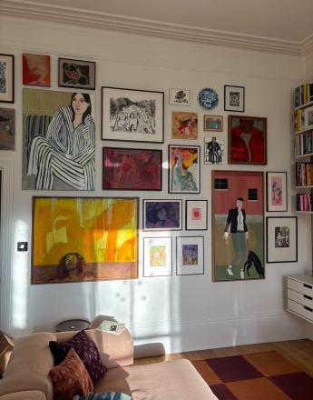 A sunny living room with a large gallery wall of diverse framed artwork and a pink L-shaped sectional sofa.
